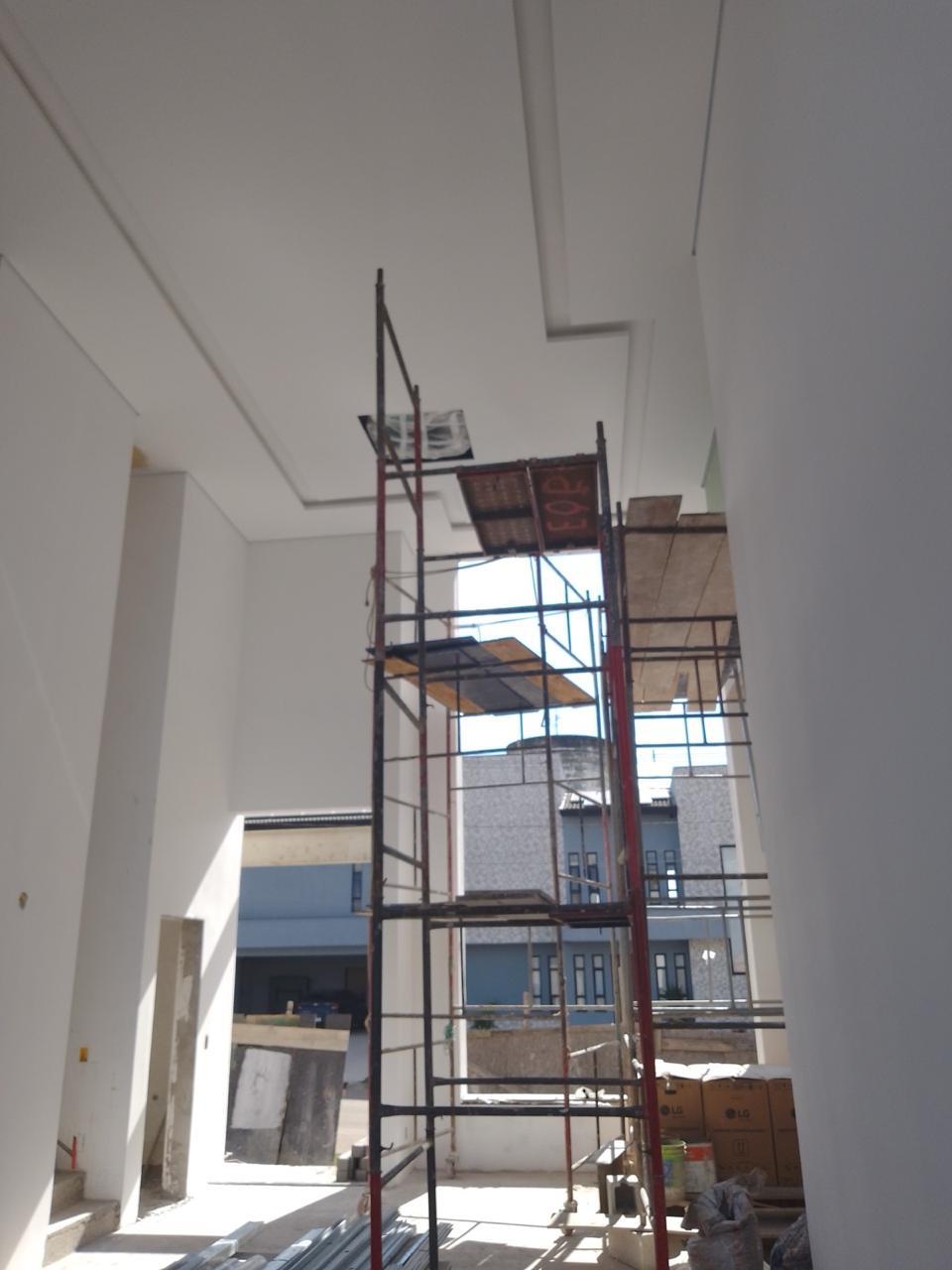 interior de construção com escada de andorinha e edifícios ao fundo  — texto:  